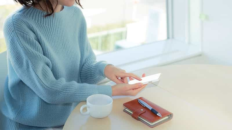 スマートフォンでお問合わせをしている人