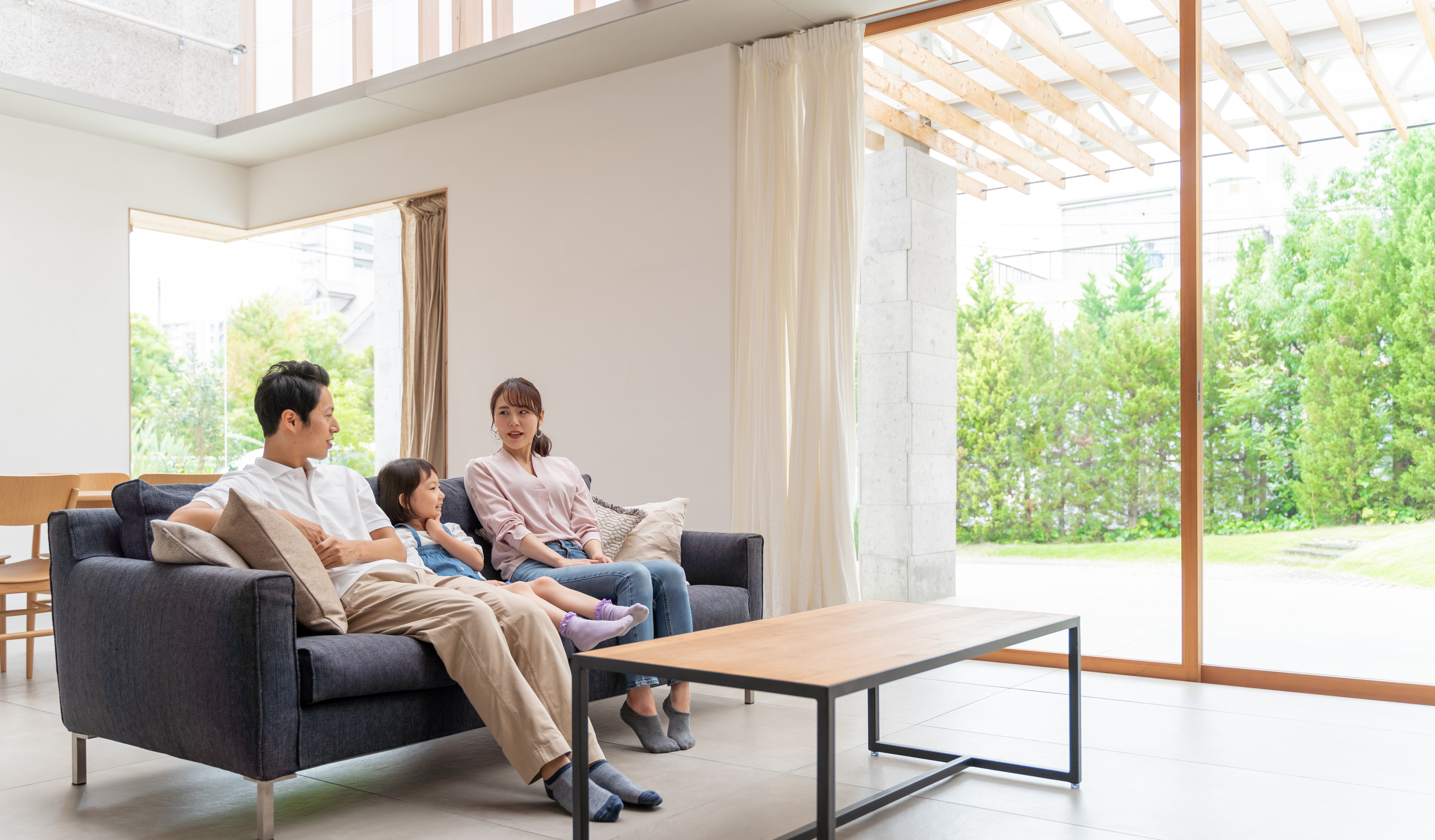 住宅会社のカタログを見ながら予算を話し合う30代夫婦のイラスト